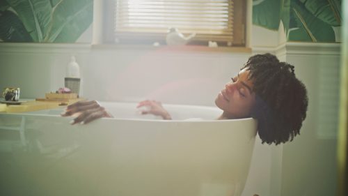 Woman lying in a bathtub, relaxing in hot water.