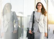 Female businesswoman in beige suit walking next to building