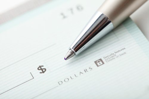 Close up photo of a pen and blank dollar check