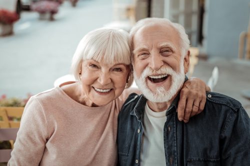 man and woman smiling at camera, celebrating their anniversary