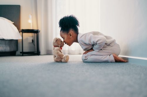 little girl playing with a teddy bear