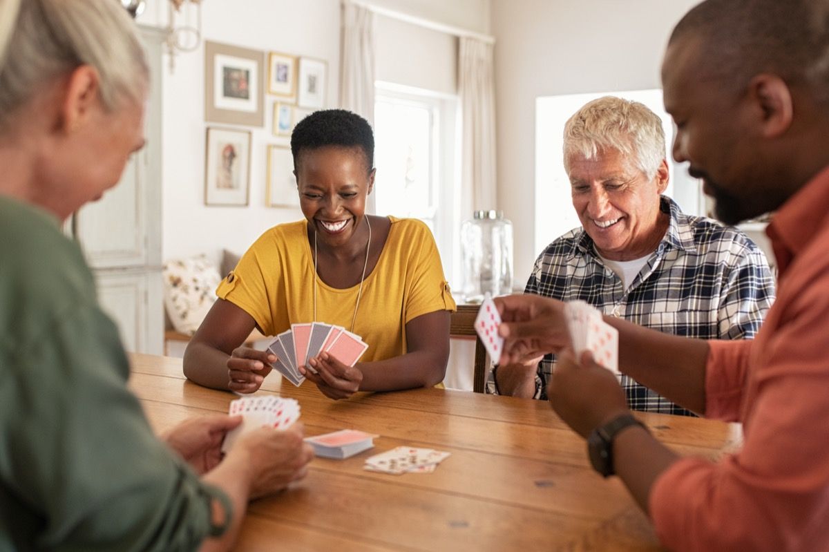 group of people sitting around a table playing cards