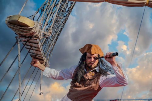 Pirate looking through telescope on pirate ship