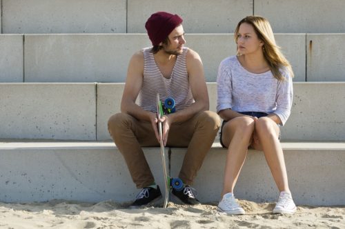 man and woman sitting on large concrete steps having a deep conversation