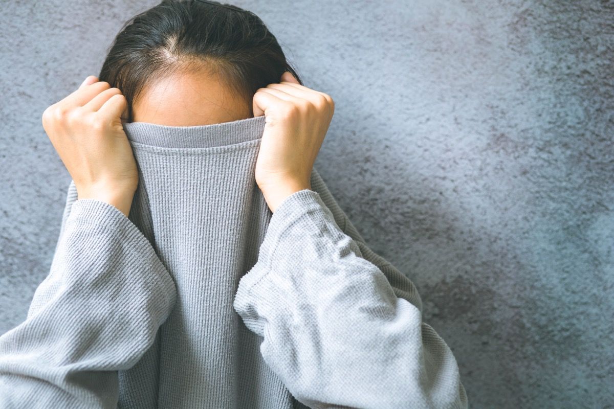 woman hiding under her shirt