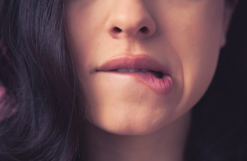 close-up of woman biting her lip