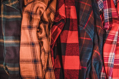 close up of several colored flannel shirts