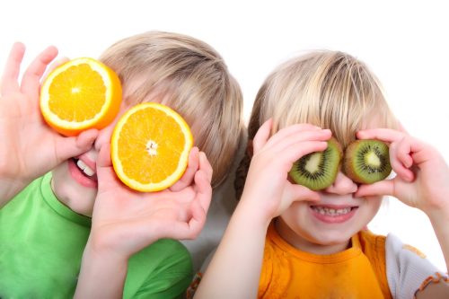 two children playing with fruit
