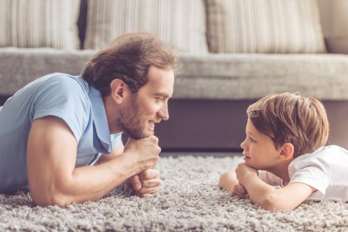 man and son asking each other funny questions while laying on the floor