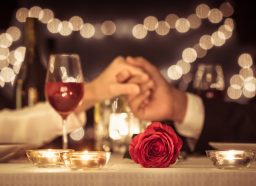 couple holding hands at a restaurant exchanging happy anniversary messages