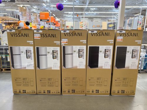 Tall Vissani brand refrigerators on display inside an appliance department of a Home Depot store.