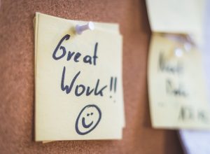 Close up of pinned note “Great work” on cork board