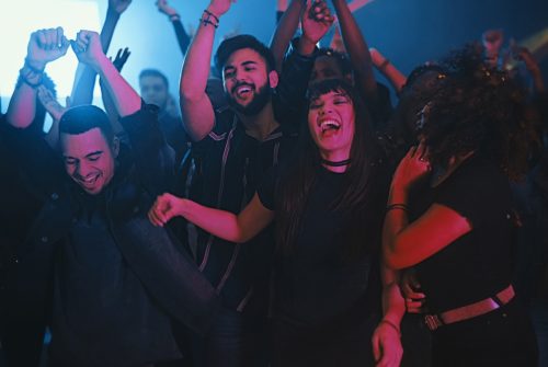 Cropped shot of a group of energetic young friends dancing at a party in a nightclub