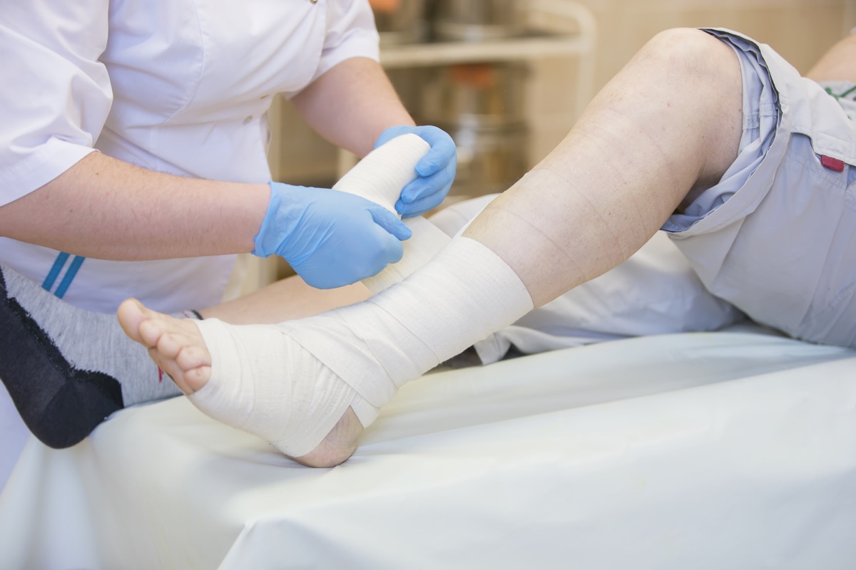 nurse bandaging a patient's lower leg
