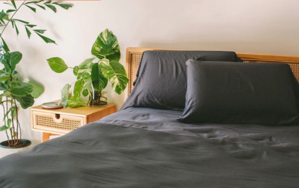 A slate-colored Nest bamboo sheet set on a mattress