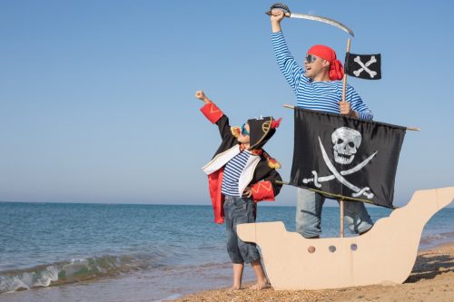 father and son dressed up like pirates on the beach