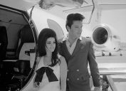 Priscilla and Elvis Presley in front of a plane following their wedding in 1967