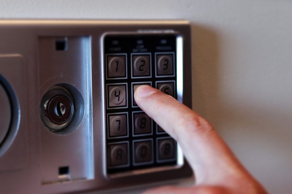 Blurred safe with combination lock and human hand in a hotel room