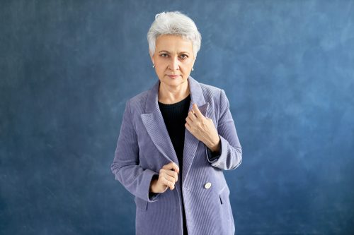 Senior woman with gray short hair wearing gray corduroy blazer
