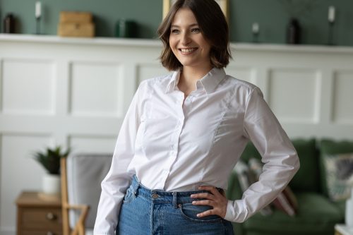 Young smiling woman in button-down shirt and jeans