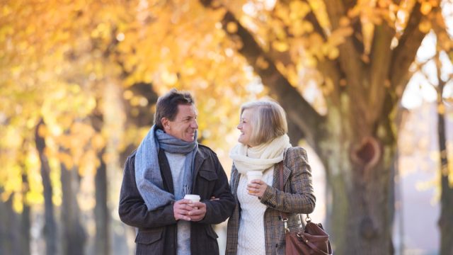 mature man and woman walking through town in autumn
