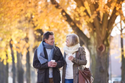 mature man and woman walking through town in autumn
