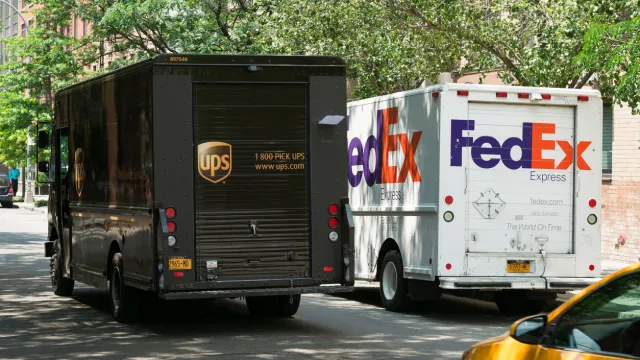 A UPS truck and a FedEx truck parked next to each other on a street