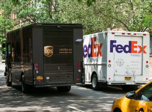 A UPS truck and a FedEx truck parked next to each other on a street