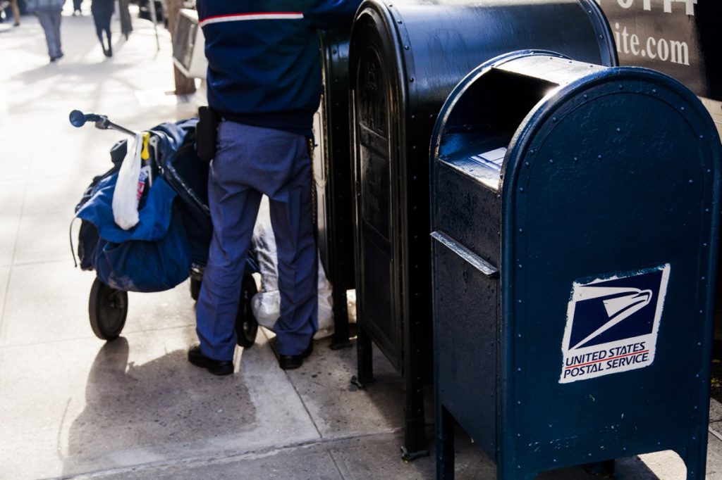 USPS worker emptying the mailbox on a Manhattan street
