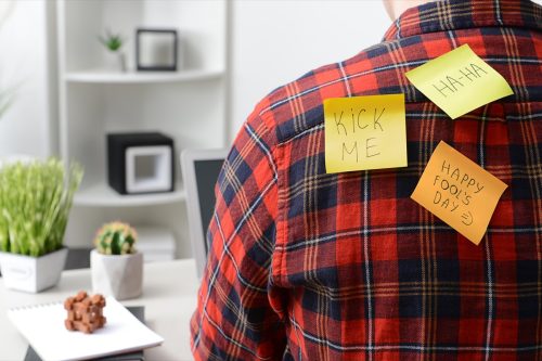 Sticky notes on back of young man working in office.
