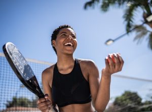 Happy woman celebrating during beach tennis match