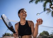 Happy woman celebrating during beach tennis match