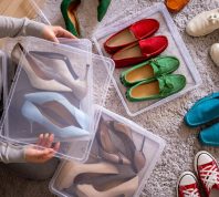 Overhead view of a woman putting shoes in plastic bins.