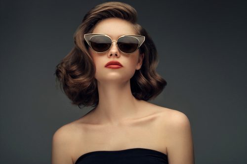 A young woman wearing retro sunglasses with a retro hairstyle