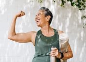 Happy older woman celebrating her fitness achievement after a great outdoor workout session, flaunting her strong bicep. Fit senior woman expressing her pride in her successful exercise routine.