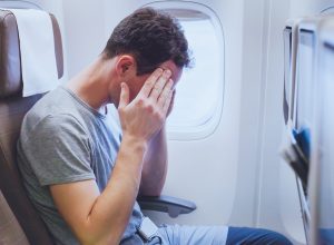 Man feeling scared on airplane during turbulence