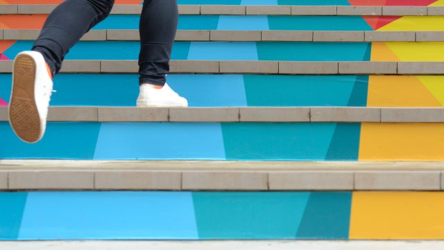 Girl walking up colorful stairs
