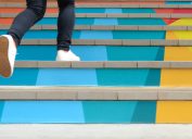 Girl walking up colorful stairs