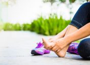 Young woman massaging her painful foot from exercising and running Sport and excercise concept.