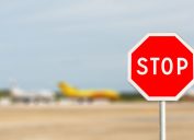 Red Stop sign on blured Airplane of Airliners are parking in International Airport.