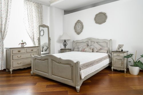 A bedroom with a matching gray-wood furniture set