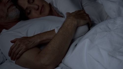 mature man and woman embracing before bed