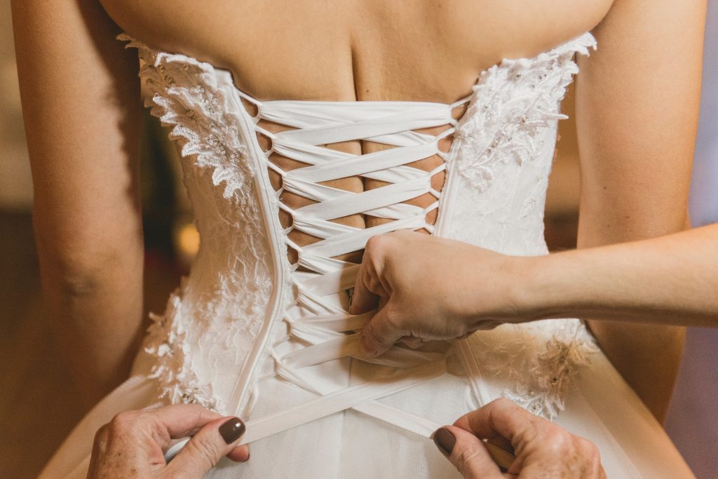 A closeup of someone tying a corset