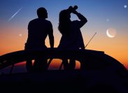 A couple sitting on the roof of a car with binoculars and watching the night sky and shooting stars