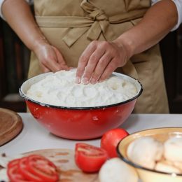 A close up of someone cooking using a vintage enamel bowl
