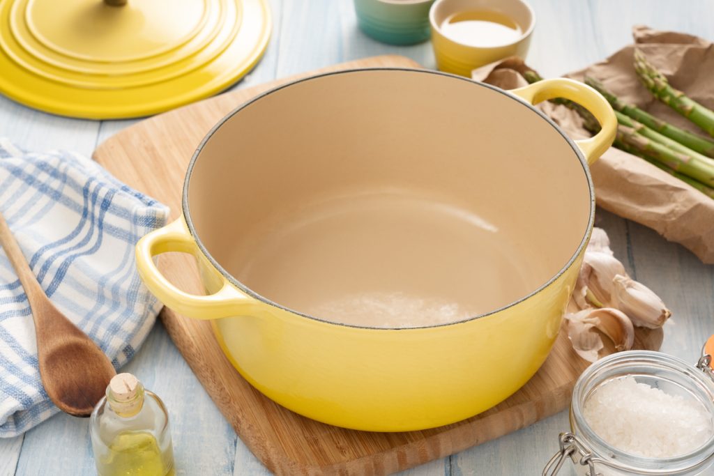 A close up of a yellow enameled cast iron dutch oven on a kitchen countertop