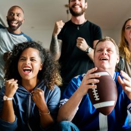 Friends cheering for football team together