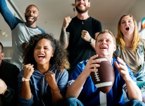 Friends cheering for football team together