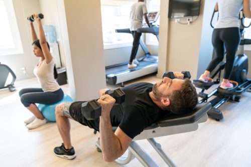 group of guests are using exercise machines at hotel gym