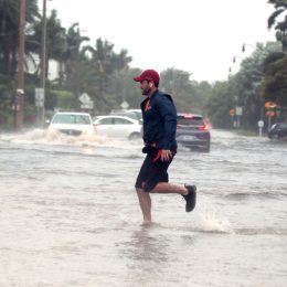 Storm Nicole nears hurricane strength as a man jogs through flooded roads in the Palm Beach area.